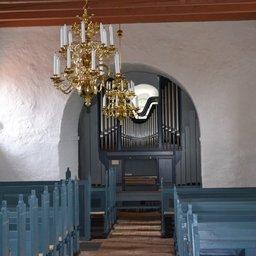 Bag de flotte lysekroner med levende lys ses kirkens Husted orglet fra 2011 - Husby kirke